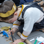 Child colouring in a cardboard castle